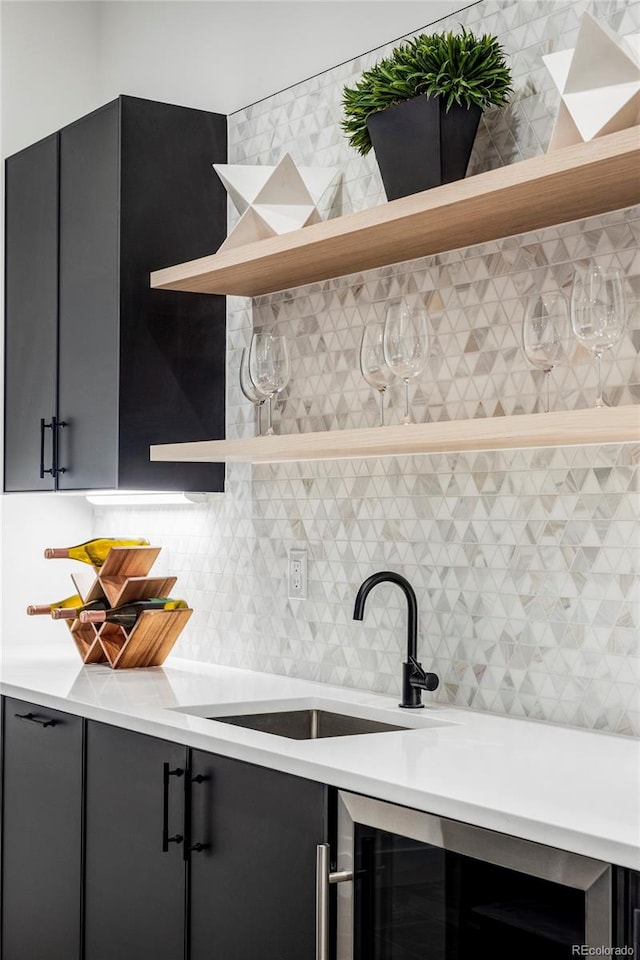 kitchen featuring backsplash, sink, and beverage cooler