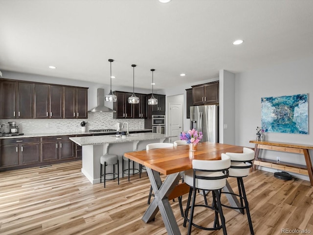 dining room with recessed lighting and light wood-style floors