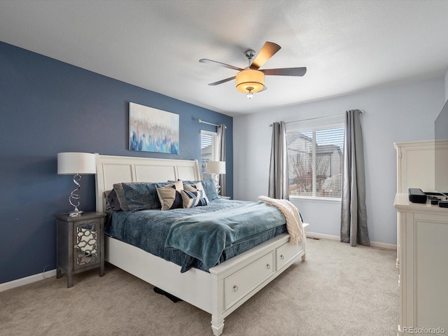 bedroom with multiple windows, light colored carpet, and baseboards