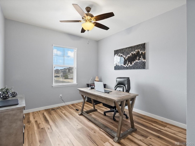 home office with light wood-style floors, baseboards, and a ceiling fan