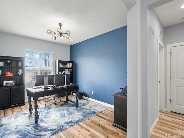 office space featuring a chandelier, wood finished floors, baseboards, and visible vents