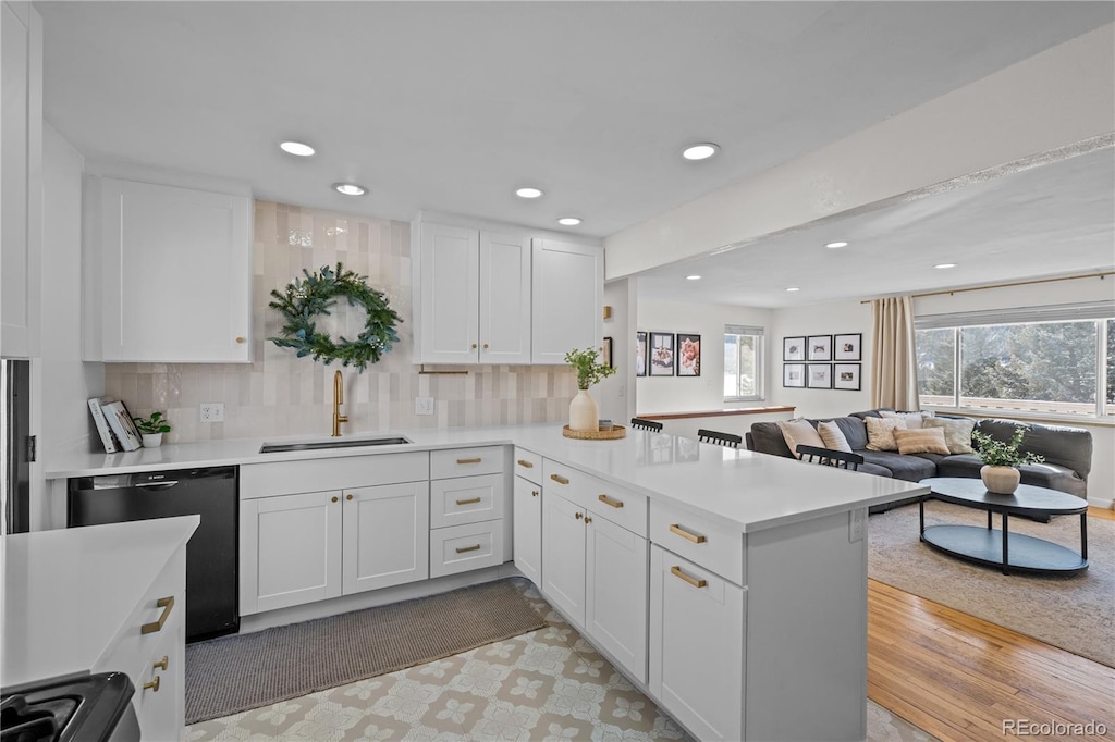 kitchen with white cabinetry, kitchen peninsula, and sink