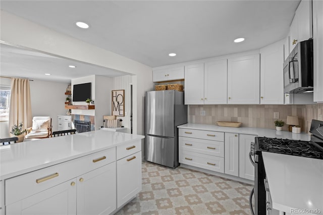 kitchen with white cabinetry, appliances with stainless steel finishes, and tasteful backsplash