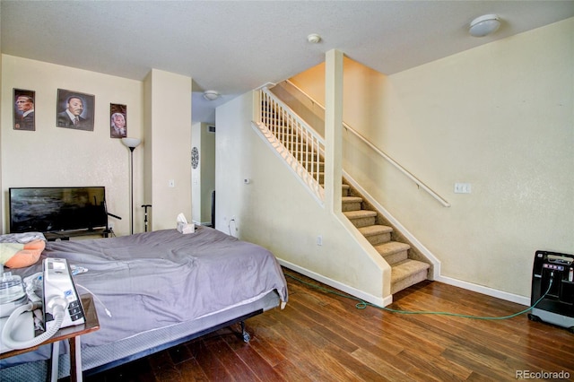 bedroom with baseboards and wood finished floors