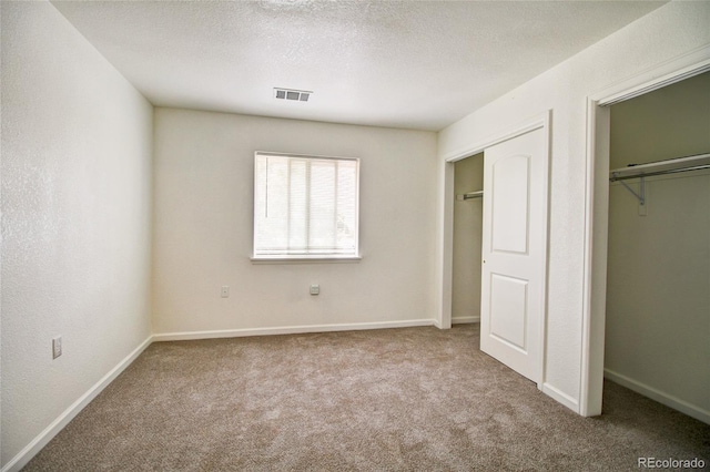 unfurnished bedroom featuring visible vents, baseboards, carpet, and a textured ceiling