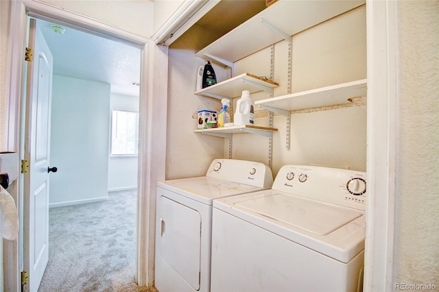 laundry room with baseboards, light colored carpet, washing machine and dryer, and laundry area