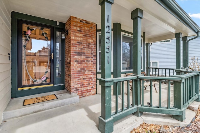 12551 W 84th Cir, Arvada, CO 80005 - doorway to property featuring covered porch and brick siding