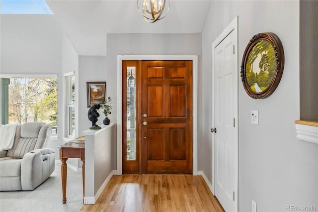 12551 W 84th Cir, Arvada, CO 80005 - entrance foyer featuring light wood finished floors, baseboards, and a notable chandelier
