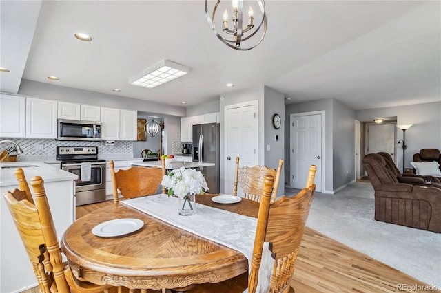 12551 W 84th Cir, Arvada, CO 80005 - dining room with recessed lighting, baseboards, a chandelier, and light wood-style floors