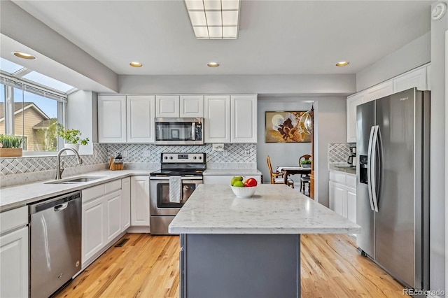 12551 W 84th Cir, Arvada, CO 80005 - kitchen with backsplash, white cabinetry, stainless steel appliances, and a sink