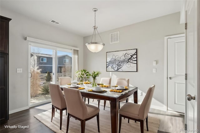 dining room with baseboards, visible vents, and dark wood-style flooring