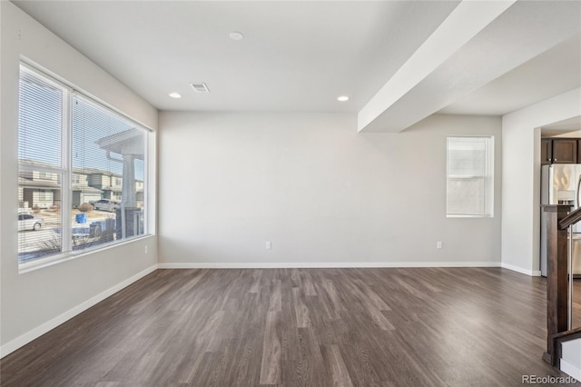 empty room featuring recessed lighting, dark wood-style flooring, visible vents, and baseboards