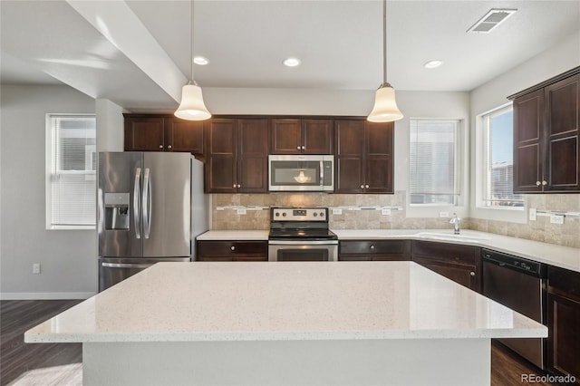 kitchen featuring appliances with stainless steel finishes, visible vents, a sink, and tasteful backsplash