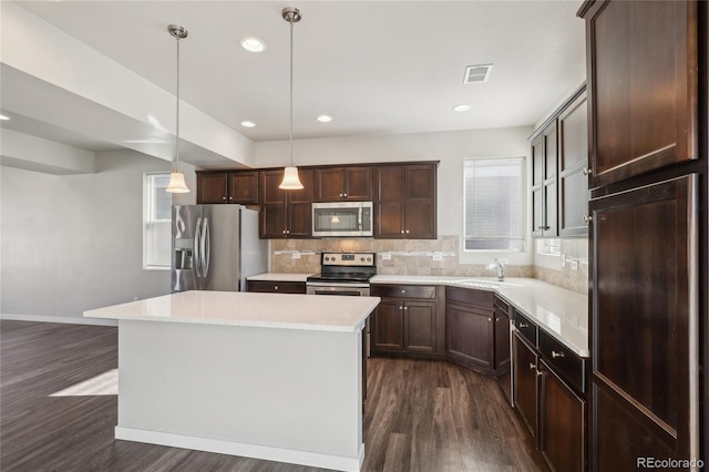 kitchen featuring visible vents, decorative backsplash, dark wood-style floors, appliances with stainless steel finishes, and light countertops