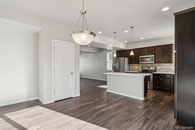 kitchen featuring dark brown cabinetry, tasteful backsplash, dark wood finished floors, appliances with stainless steel finishes, and light countertops