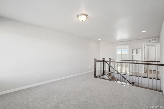 spare room with recessed lighting, carpet flooring, visible vents, and baseboards