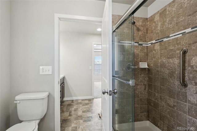 full bathroom featuring a stall shower, vanity, toilet, and baseboards