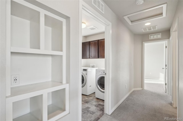 clothes washing area with independent washer and dryer, cabinet space, visible vents, and attic access