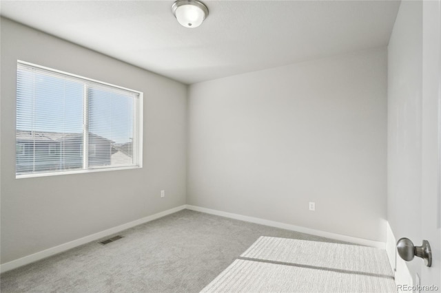 carpeted spare room with visible vents and baseboards