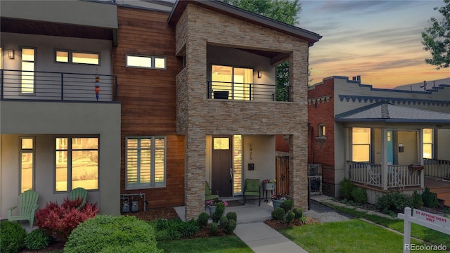 1426 S Pearl St, Denver, CO 80210 - modern home featuring stone siding, covered porch, stucco siding, and a balcony