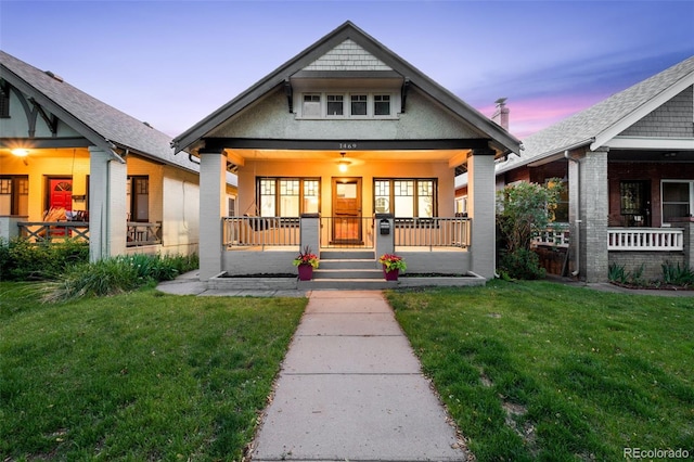view of front of house featuring covered porch and a lawn
