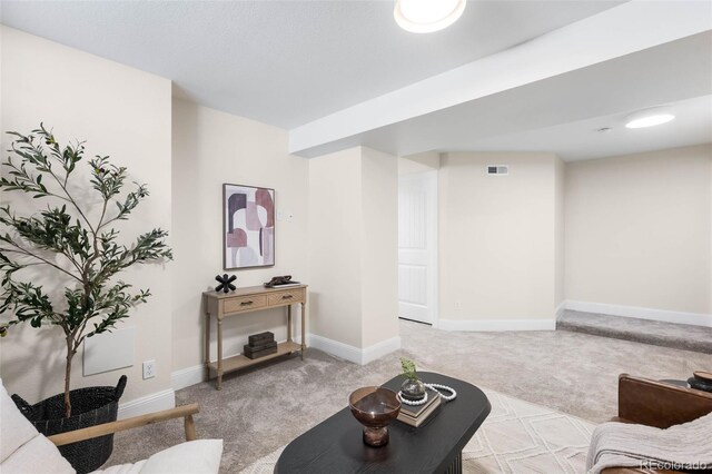 living area featuring light carpet and baseboards