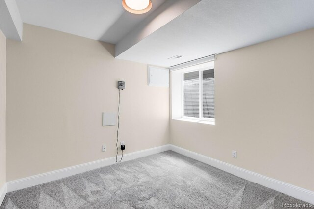 spare room featuring carpet floors and baseboards