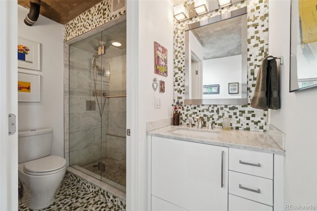 bathroom with toilet, a shower with door, vanity, and tasteful backsplash