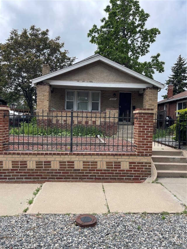 3036 W Clyde Pl, Denver, CO 80211 - bungalow featuring a chimney, brick siding, a fenced front yard, and covered porch