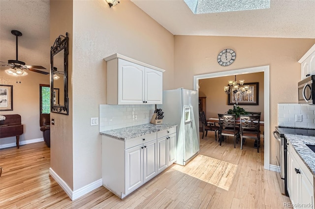 3752 S Helena Way, Aurora, CO 80013 - kitchen with stainless steel appliances, light wood-style flooring, tasteful backsplash, white cabinetry, and a ceiling fan