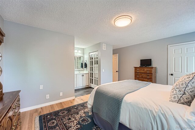 3752 S Helena Way, Aurora, CO 80013 - bedroom with light wood-style floors, a textured ceiling, and ensuite bath