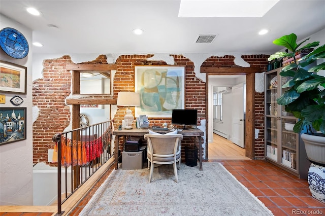 home office with a baseboard radiator, brick wall, and tile patterned floors