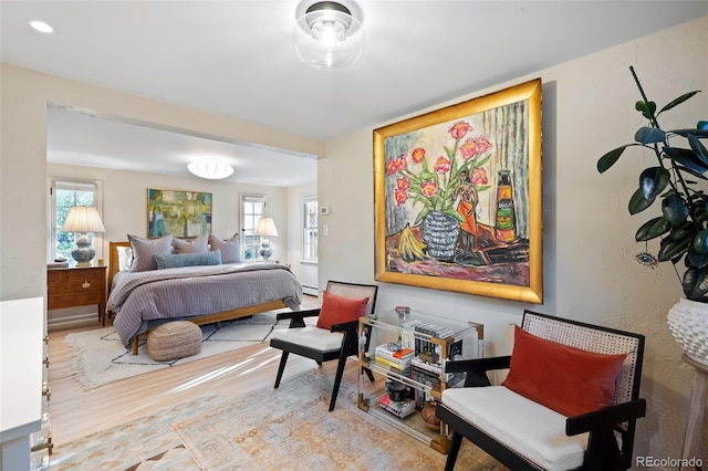 bedroom featuring a baseboard heating unit and multiple windows