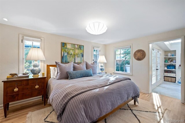 bedroom with light wood-type flooring and multiple windows