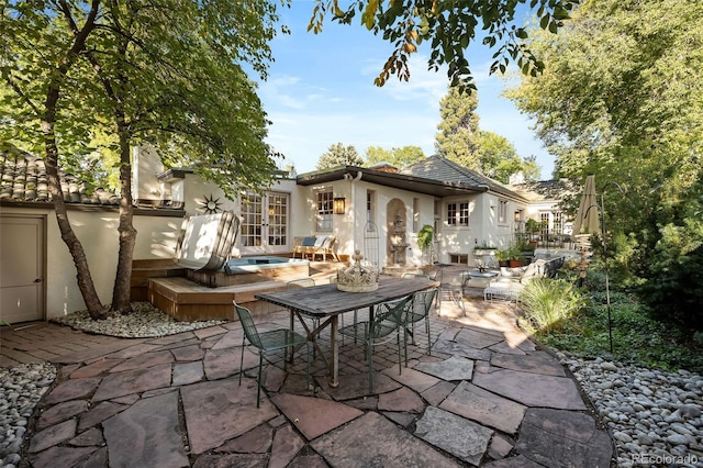 view of patio / terrace with a jacuzzi and french doors