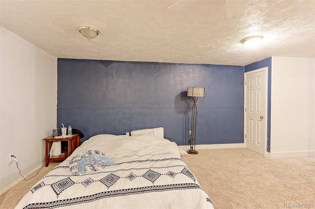 bedroom with light colored carpet, a textured ceiling, and baseboards