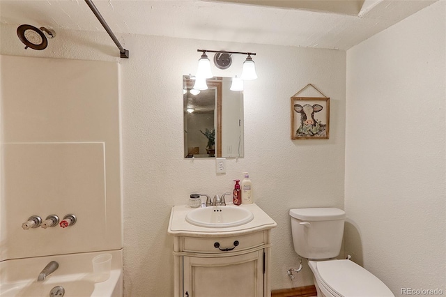 bathroom featuring toilet, a textured wall, shower / bath combination, and vanity