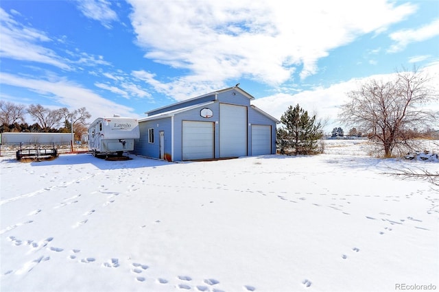 snow covered garage featuring a garage