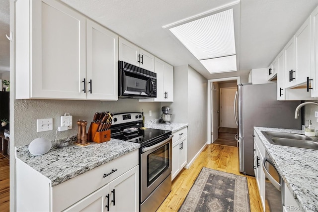 7905 Lowell Blvd Unit B, Westminster, CO 80030 - kitchen with appliances with stainless steel finishes, light wood-style flooring, white cabinetry, and light stone counters