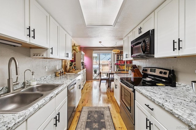 7905 Lowell Blvd Unit B, Westminster, CO 80030 - kitchen with appliances with stainless steel finishes, light wood-type flooring, and white cabinets