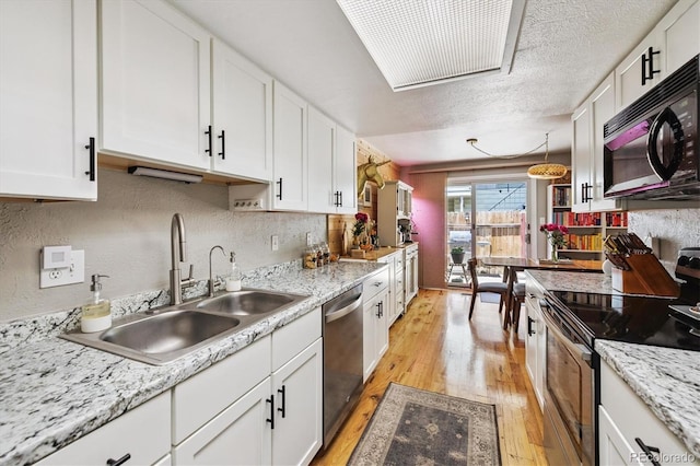 7905 Lowell Blvd Unit B, Westminster, CO 80030 - kitchen with stainless steel appliances, light wood finished floors, white cabinetry, light countertops, and tasteful backsplash
