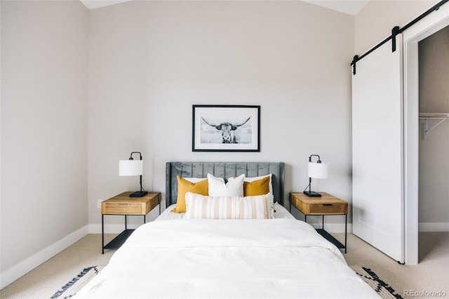 carpeted bedroom with baseboards and a barn door