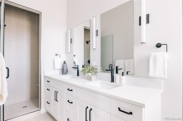 full bath featuring a sink, double vanity, and a shower stall