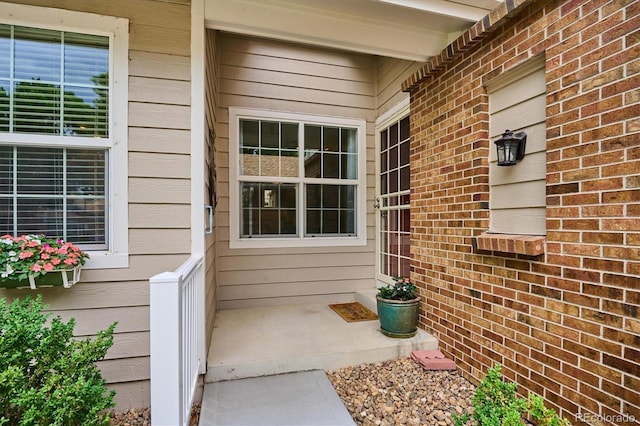 view of exterior entry featuring brick siding