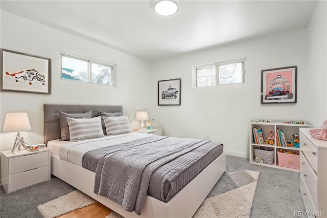 carpeted bedroom featuring multiple windows and baseboards