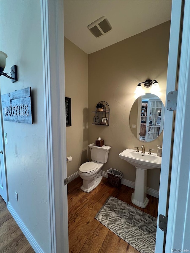 bathroom with wood-type flooring and toilet