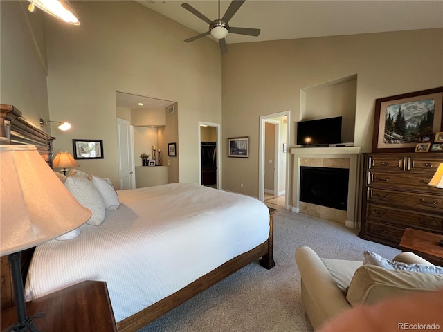 bedroom featuring a spacious closet, a closet, ceiling fan, high vaulted ceiling, and light colored carpet