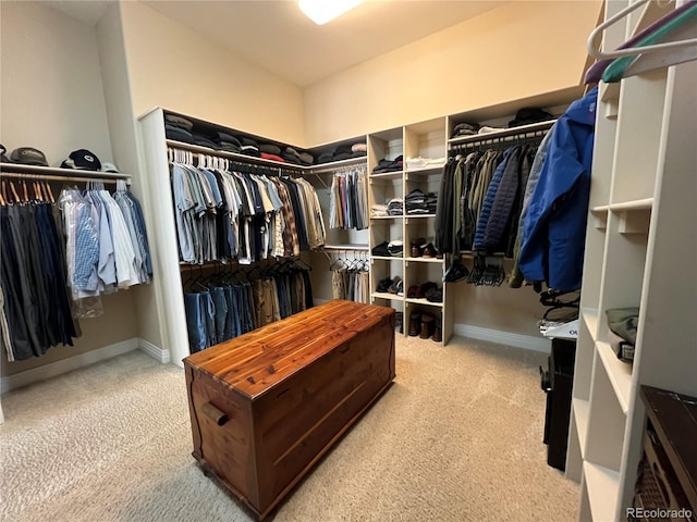 walk in closet with light carpet