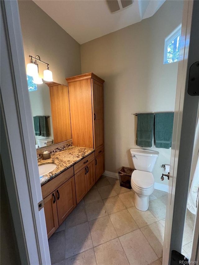 bathroom with vanity, toilet, and tile patterned floors