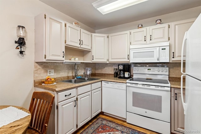 kitchen with white appliances, tasteful backsplash, white cabinetry, and sink